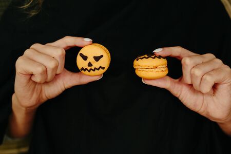 woman holding a biscuit for Halloween on black backgroundの写真素材