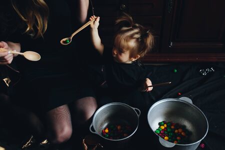mother and daughter playing together at home on Halloweenの写真素材