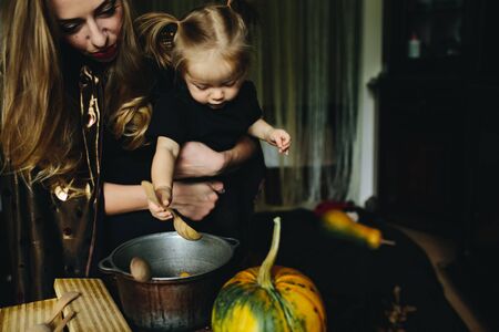 mother and daughter playing together at home on Halloweenの写真素材