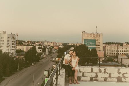 beautiful couple together on the roof of a tall buildingの写真素材