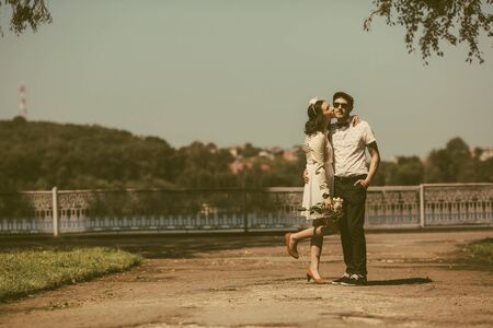 beautiful couple gently hugging the shores of a large lakeの写真素材