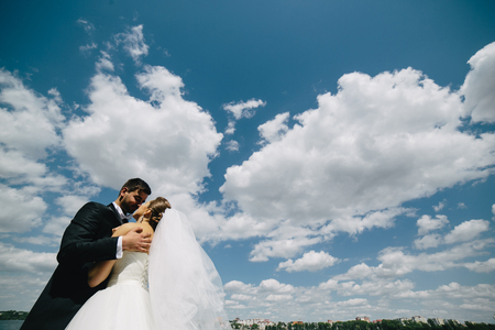Beautiful wedding couple on the background of blue sky, waterの写真素材