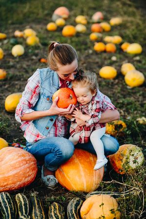 Mother and daughter sitting on pumpkins, Halloween eveの写真素材
