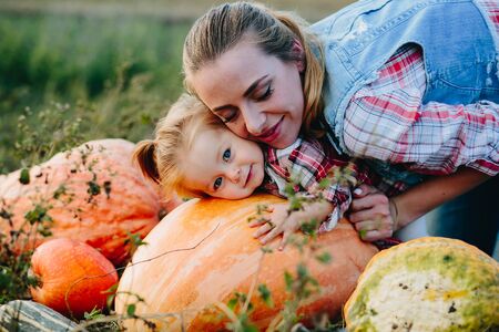 daughter lying on a pumpkin, and her mother standing beside, Halloween eveの写真素材