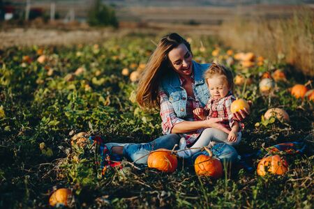 mother and daughter on a field with pumpkins, Halloween eveの写真素材