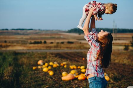 mother and daughter on a field with pumpkins, Halloween eveの写真素材