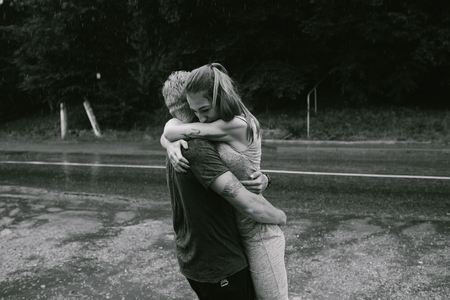 man throws up his girlfriend in the rainの写真素材