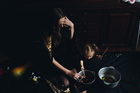mother and daughter playing together at home on Halloweenの写真素材