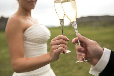bridal couple clink glasses of champagne on the natureの写真素材