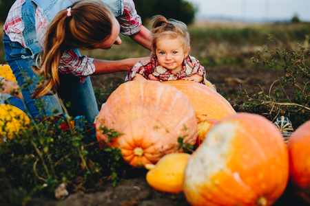 daughter lying on a pumpkin, and her mother standing beside, Halloween eveの写真素材
