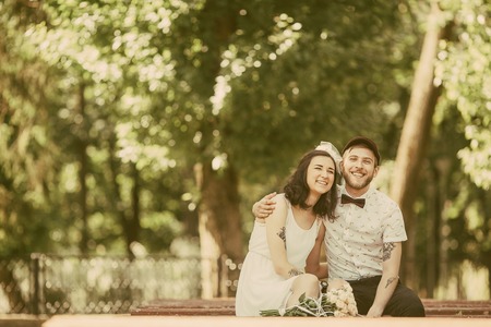 beautiful couple sits on a bench in the park and having funの写真素材