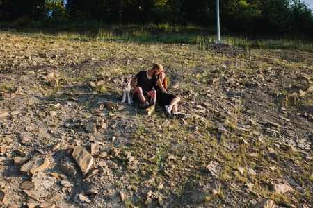 beautiful couple sits on a hill and hugging each otherの写真素材
