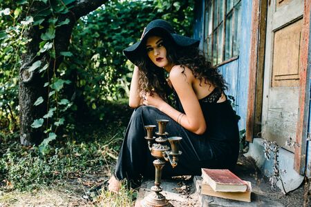Vintage woman as witch, posing beside an abandoned building on the eve of Halloweenの写真素材