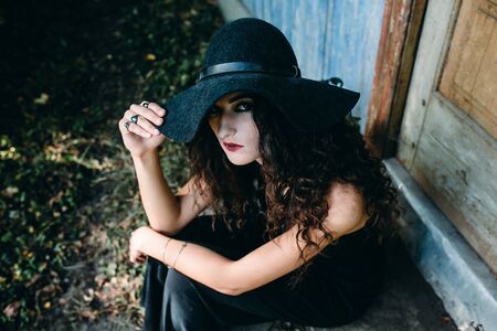 Vintage woman as witch, posing beside an abandoned building on the eve of Halloweenの写真素材