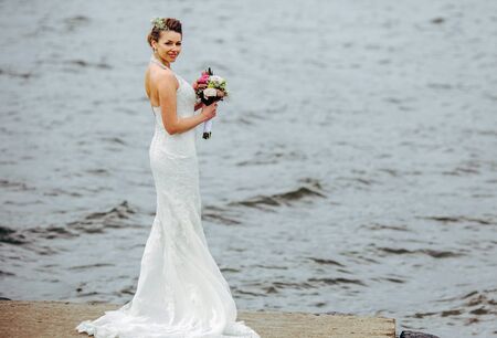 Bride posing on the pier at the lakeの写真素材