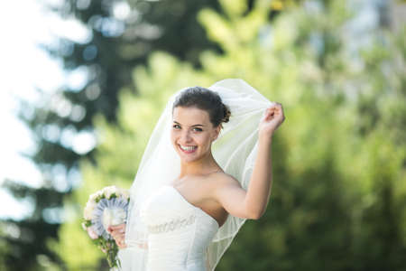 young beautiful bride in nature looking at the camera and smilingの写真素材