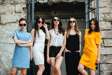 Five young beautiful girls posing against the backdrop of an abandoned buildingの写真素材