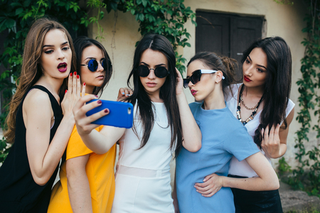 five beautiful young girls make selfie on the street near houseの写真素材