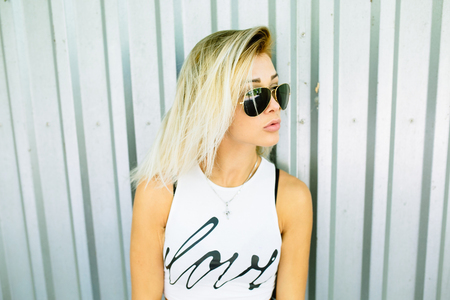 beautiful blonde posing on a background of metal wallの写真素材