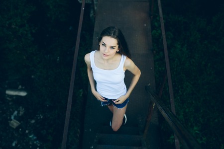 young beautiful girl posing while standing in an abandoned structureの写真素材