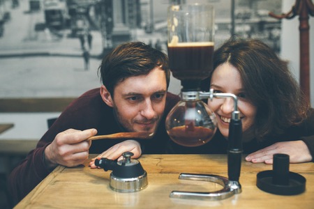 Vintage couple preparing coffee with vacuum coffee makerの写真素材