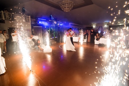 beautiful bride and groom dancing the first dance between fireworksの写真素材