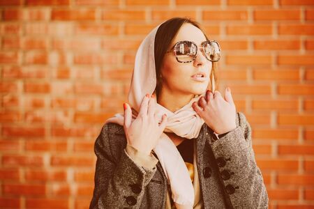young and beautiful girl posing on a background of red brick wall, close angle.の写真素材