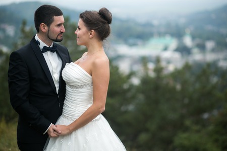 Wedding couple in nature against the backdrop of the city awayの写真素材