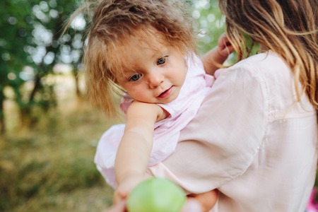 Happy mother and daughter laughing together outdoorsの写真素材