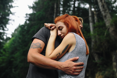 man and woman tenderly hugging in natureの写真素材