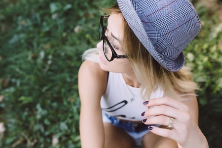 beautiful girl sitting and looking to the side, sunny, summer dayの写真素材