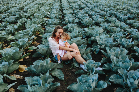 Mom and daughter having fun on the field with cabbageの写真素材