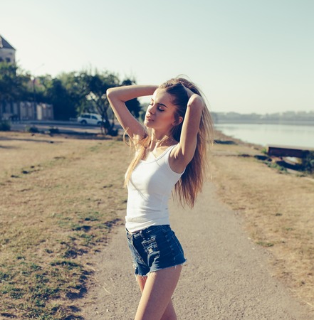 Photo of a beautiful young girl on the sidewalk near the beachの写真素材