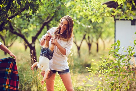 mom and little girl having fun in the gardenの写真素材