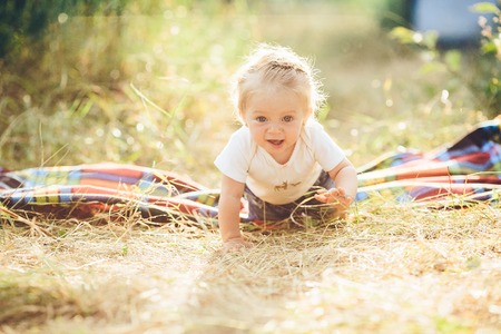 little girl crawling on the lawn at the farmの写真素材