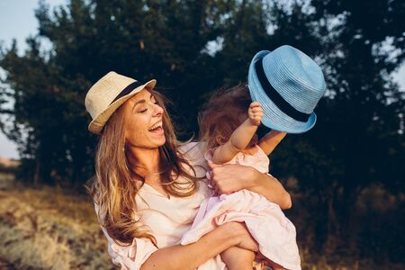 Happy mother and daughter laughing together outdoorsの写真素材