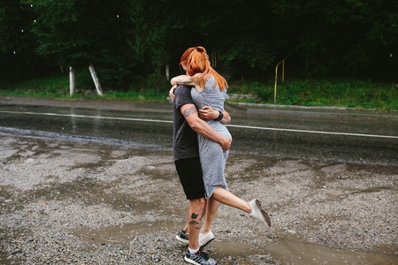 man throws up his girlfriend in the rainの写真素材