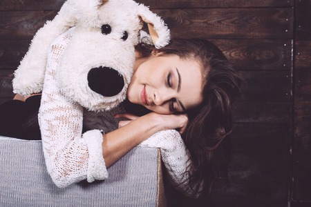 Cute little girl hugging a cute toy. Christmas backgroundの写真素材
