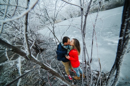 beautiful couple posing near a frozen river in the parkの写真素材