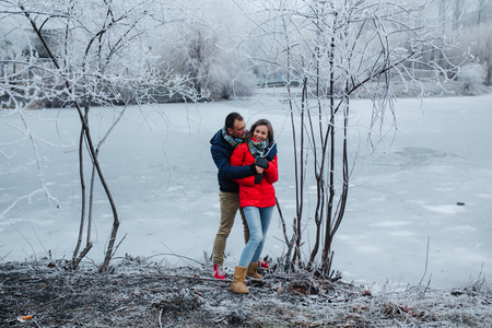 beautiful couple posing near a frozen river in the parkの写真素材