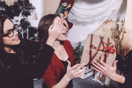 Beautiful girl exchange gifts for the new year. Decorative vintage apartment.の写真素材