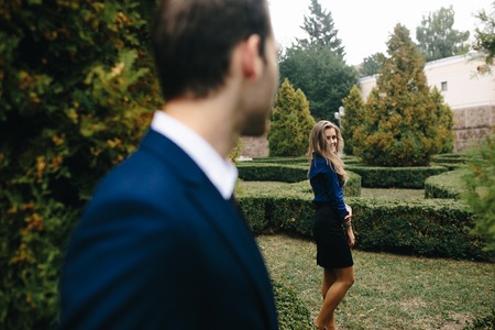 girl standing near guy in the background at the parkの写真素材