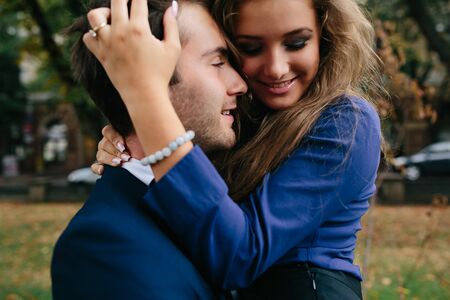 man holding his girlfriend in his arms in the park, close angleの写真素材