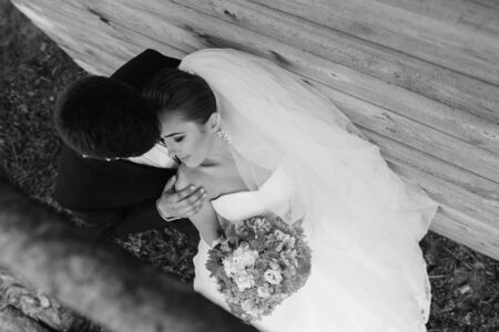 beautiful young wedding couple stands near the old wooden house. Photo from the topの写真素材