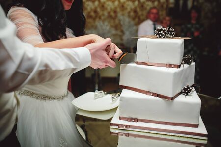 bride and groom is cutting their wedding cakeの写真素材