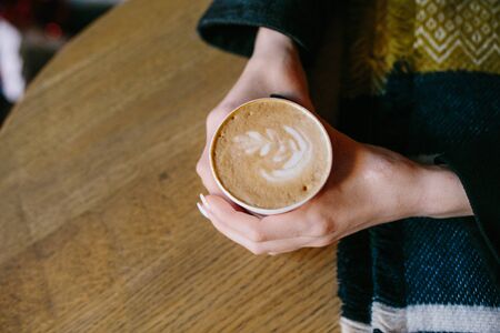 someone sits at the table and holding a hot drinkの写真素材
