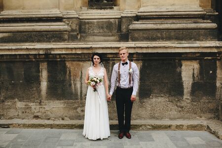 The bride and groom posing in the old street, family photoの写真素材