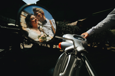 bride and groom posing on a vintage motor scooterの写真素材