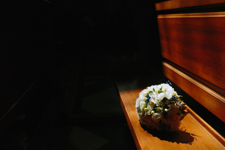 bridal bouquet lying on the bench, illuminated by the sun in the roomの写真素材