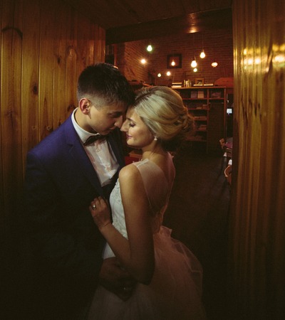 The bride and groom in a cozy house, posing for the cameraの写真素材